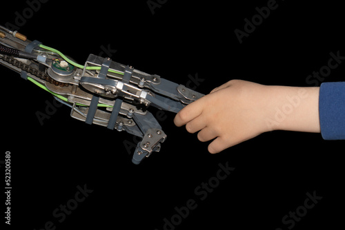 Robot giving metal hand to the child. Handshake of child and old robot.