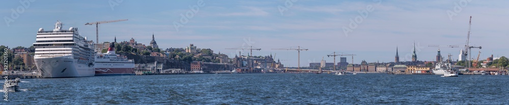 Panorama view over the bay Satsjön with cruising ships and commuting boats and the old town Gamla Stan, a sunny summer day in Stockholm