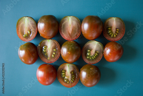 Cherry tomatoes kumato on a green-blue background close-up. photo