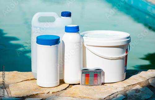 Close up photo of equipment for testing the quality of pool water and chemical cleaning products at the edge of swimming pool