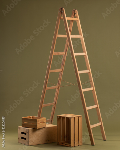 Wooden ladder and wooden box on khaki background
