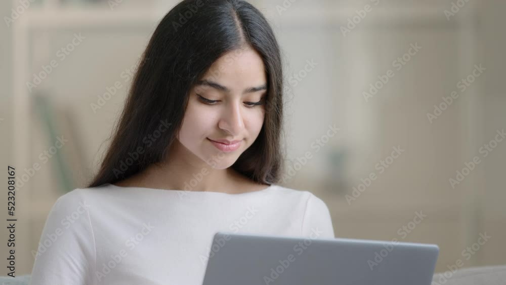 Calm concentrated young student make homework educational tasks on computer studying online at home during quarantine. Arabian girl woman working laptop learn digital information chatting use internet Calm concentrated young student make homework educational tasks on computer studying online at home during quarantine. Arabian girl woman working laptop learn digital information chatting use internet