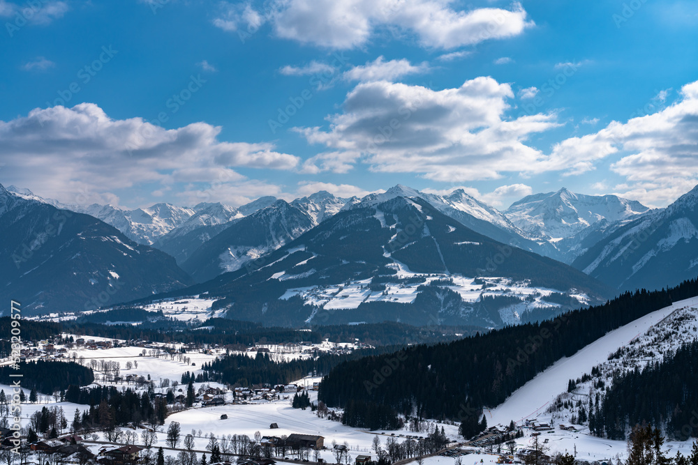 Beautiful aerial panorama view of Ramsau am Dachstein village and Schladming with Planai and other peaks of Alps in background with blue sky cloud in winter, Austria