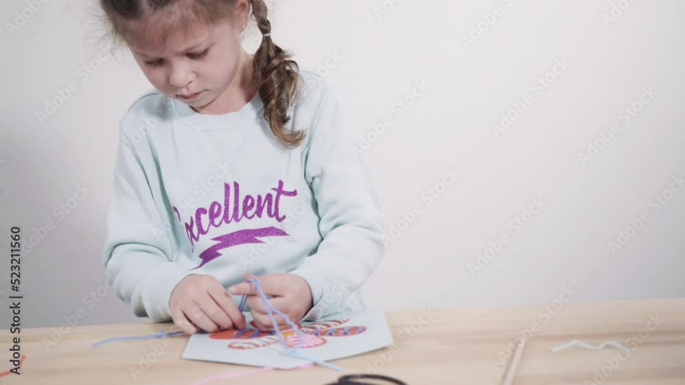 Little girl learning how to sew with sewing craft kit for kids. Little girl learning how to sew with sewing craft kit for kids.
