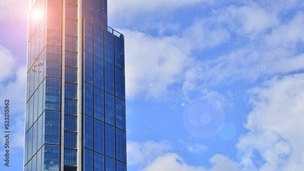 Modern glass facade against blue sky. Bottom view of a  building in the business district. Low angle view of the glass facade of an office building.