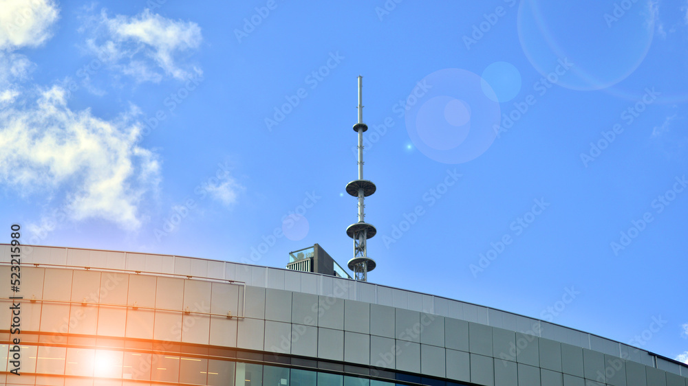 Modern glass facade against blue sky. Bottom view of a building in the business district. Low angle view of the glass facade of an office building. Modern glass facade against blue sky. Bottom view of a building in the business district. Low angle view of the glass facade of an office building.