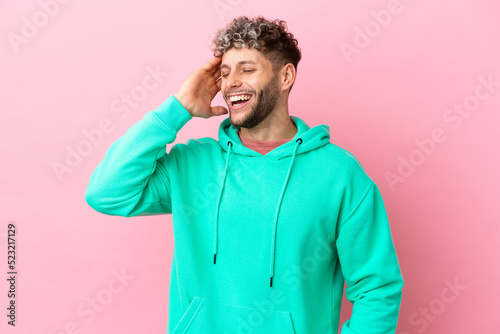 Young handsome caucasian man isolated on pink background smiling a lot © luismolinero