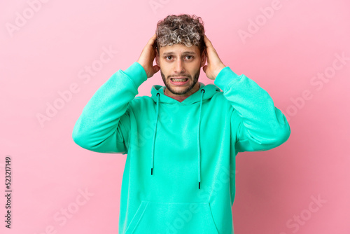 Young handsome caucasian man isolated on pink background doing nervous gesture © luismolinero