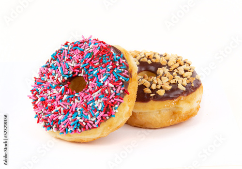 Two Fresh Chocolate Frosted Doughnuts or Donuts with Sprinkles and Chopped Nuts