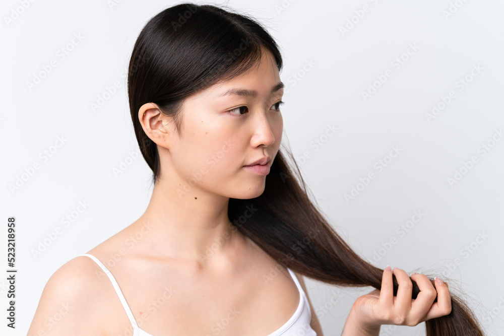 Young Chinese woman isolated on white background touching her hair. Close up portrait Young Chinese woman isolated on white background touching her hair. Close up portrait