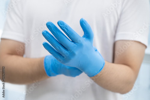 Doctor wearing blue nitrile gloves (select focus)