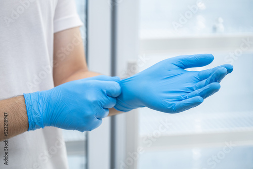 Doctor wearing blue nitrile gloves (select focus) photo