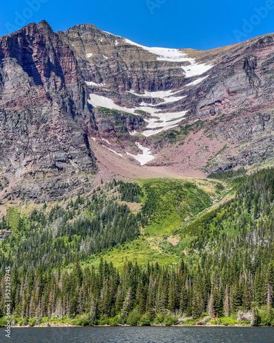 Summer snow fields on Rising Wolf Mountain rising above Two Medicine Lake, Glacier National Park, Montana, USA photo