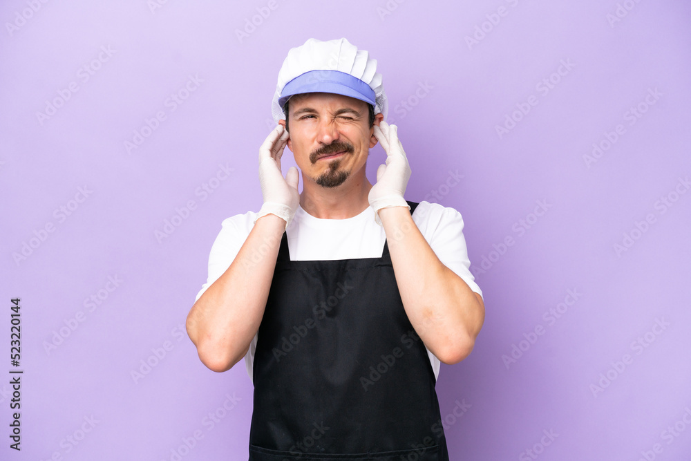 Fishmonger man wearing an apron isolated on purple background frustrated and covering ears Fishmonger man wearing an apron isolated on purple background frustrated and covering ears