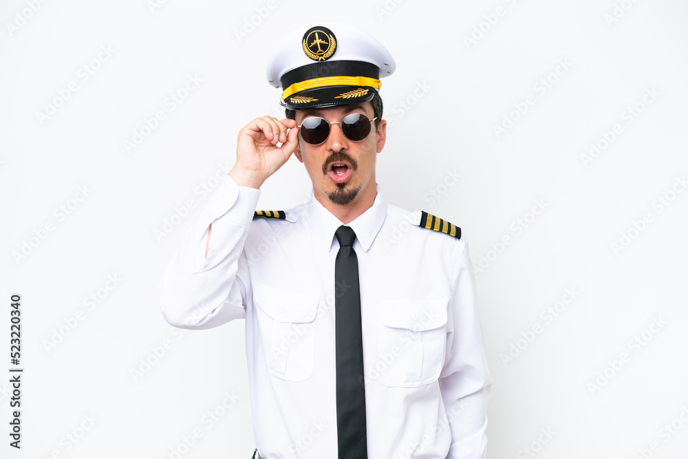Airplane caucasian pilot isolated on white background with glasses and surprised