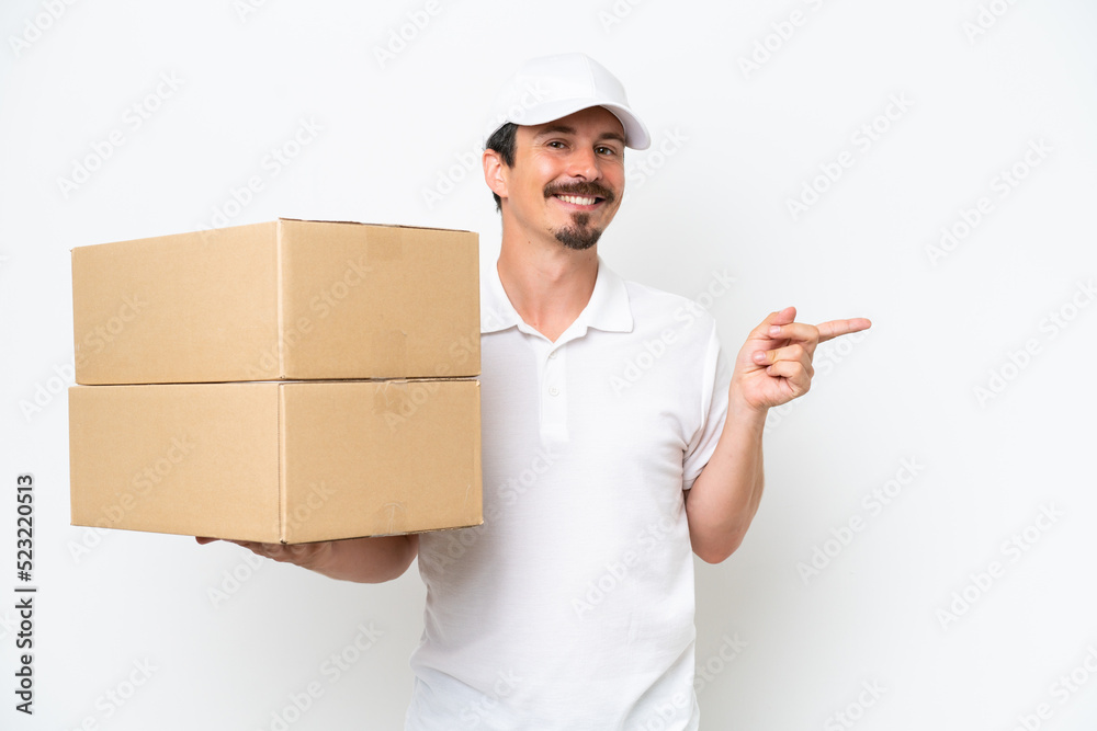 Delivery caucasian man isolated on white background pointing finger to the side Delivery caucasian man isolated on white background pointing finger to the side