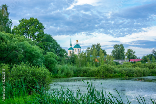 Photography duckweed covered lake kiovo, moscow region, russia, Orthodox church on the shore