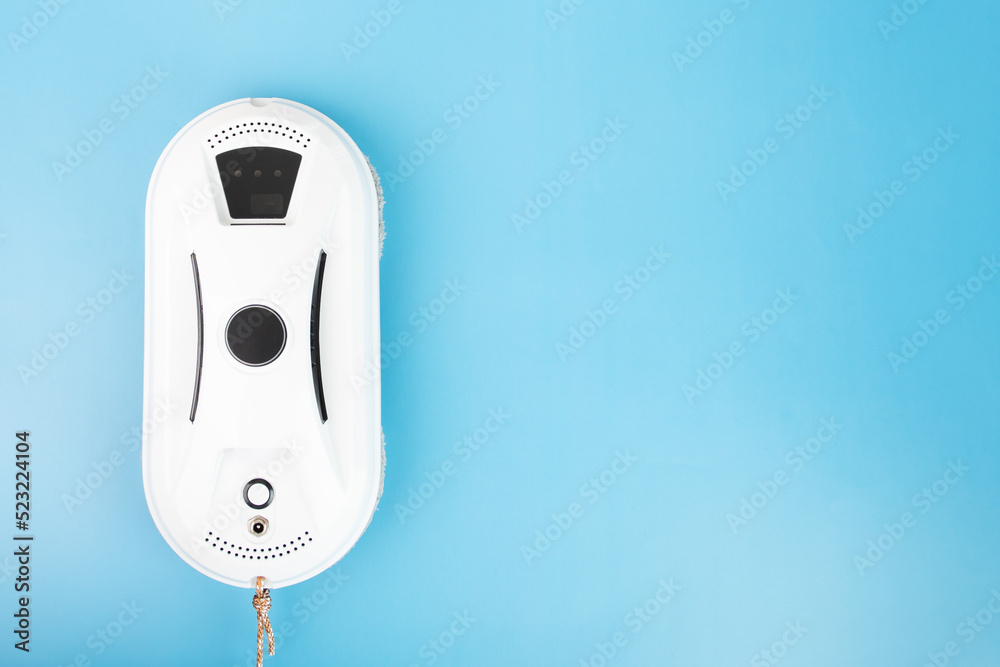 robot window cleaner, device for cleaning windows in the house on a blue background, copy space