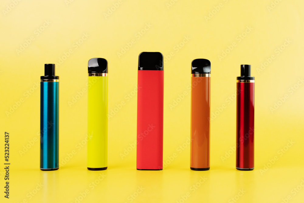 disposable vape, electronic cigarettes, smoking devices on a yellow background disposable vape, electronic cigarettes, smoking devices on a yellow background