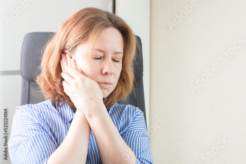 tooth disease, toothache, dental problems, a woman in the office with a toothache holds her cheek with her hand photo