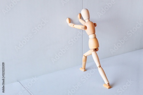 Wooden figure showing a position of stretching muscles to exercise 