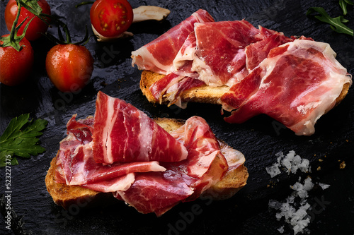 Iberian ham slices on a slice of toasted bread photo