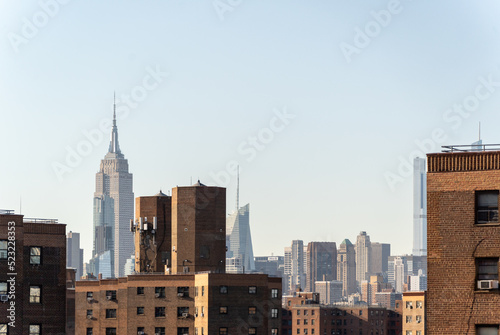 View of the Empire State Building Behind Brick Construction Residential Buildings