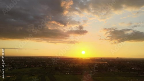 Wallpaper Mural Aerial landscape view of village houses and distant green cultivated agricultural fields with growing crops on bright summer evening Torontodigital.ca