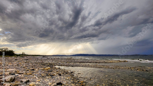 Aus finsteren Wolken bricht die Sonne hindurch photo