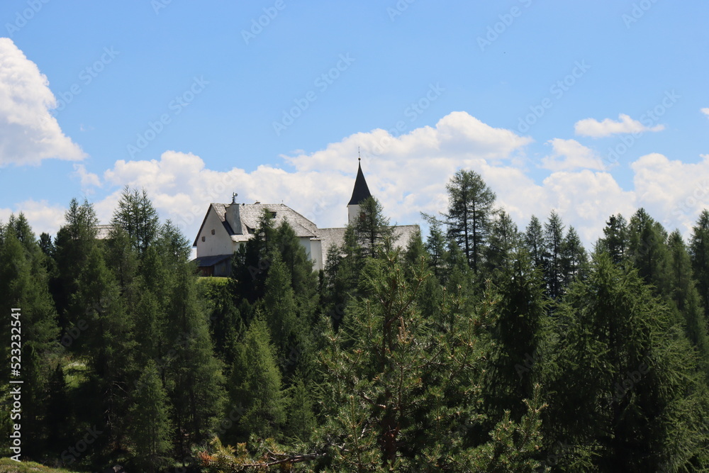 Val Badia, Italy-July 17, 2022: The italian Dolomites behind the small village of Corvara in summer days with beaitiful blue sky in the background. Green nature in the middle of the rocks. Val Badia, Italy-July 17, 2022: The italian Dolomites behind the small village of Corvara in summer days with beaitiful blue sky in the background. Green nature in the middle of the rocks.