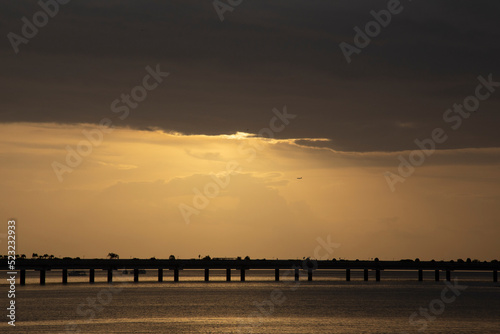 Amanecer sobre el mar con silueta de puente de Cinta Costera en Ciudad de Panamá photo