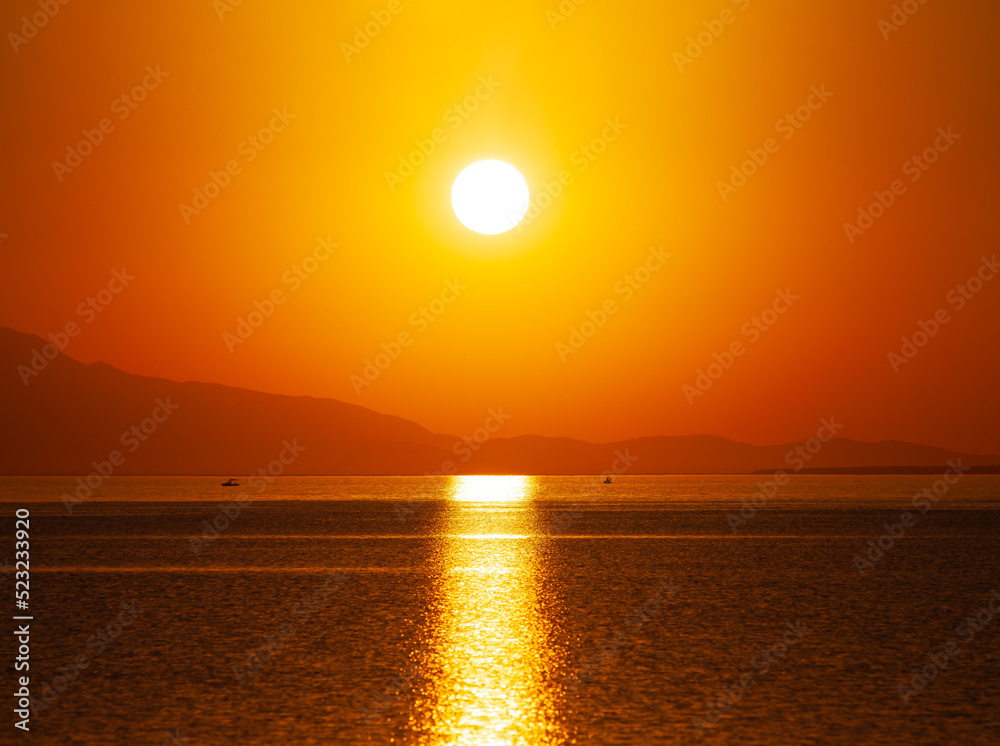 Sunset over the sea on the beach. sun on the horizon. Sunset on the coast of Turkey, Ayvalık