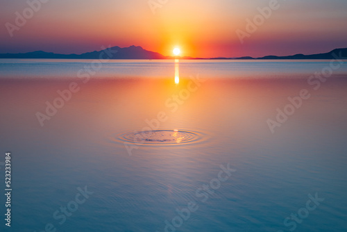 Round water waves in rings above the water at sunset. Water drops  swirls  and splashes. 