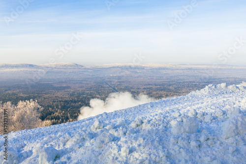 snow on the slope of the ski resort, the background is a forest winter landscape © metelevan