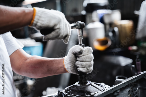 Close-up mechanic hand with his tool holding a spanner while at a garage.