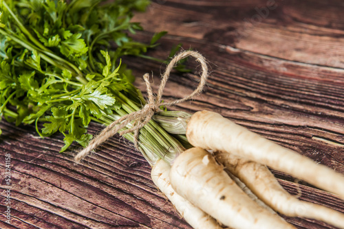 Fresh and sweet parsley on a kitchen wooden table.