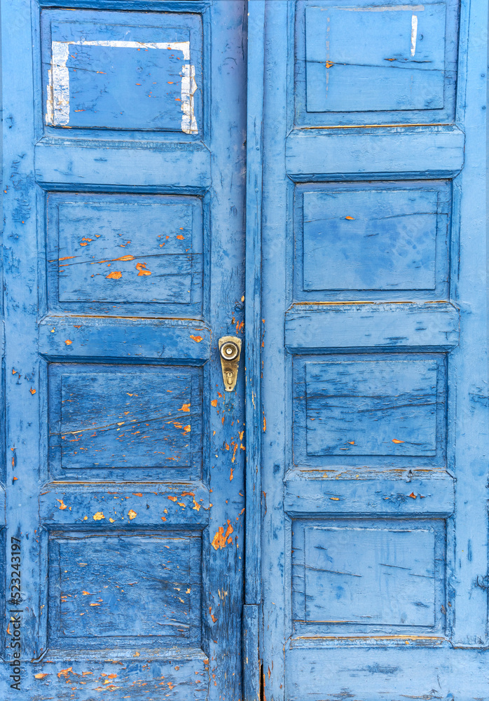 Old antique blue wooden door with paint that is peeling off.