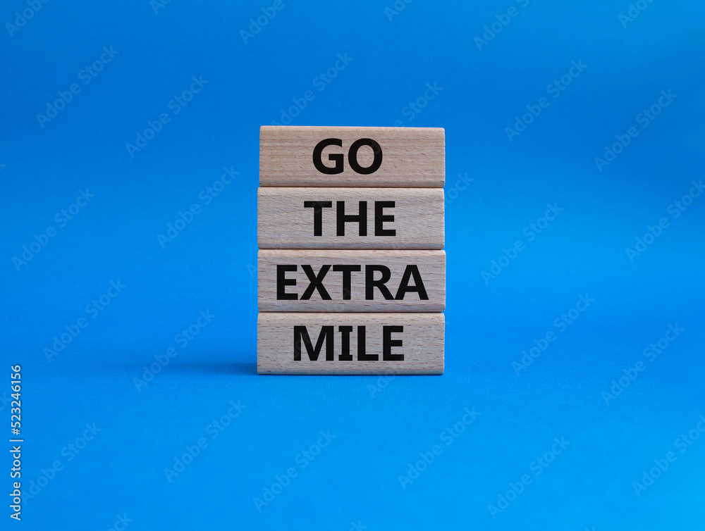 Go the extra mile symbol. Wooden blocks with words Go the extra mile. Beautiful blue background. Business and Go the extra mile concept. Copy space. Go the extra mile symbol. Wooden blocks with words Go the extra mile. Beautiful blue background. Business and Go the extra mile concept. Copy space.