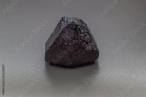 Macro focused black tourmaline schrol crystal isolated on gray background  photo