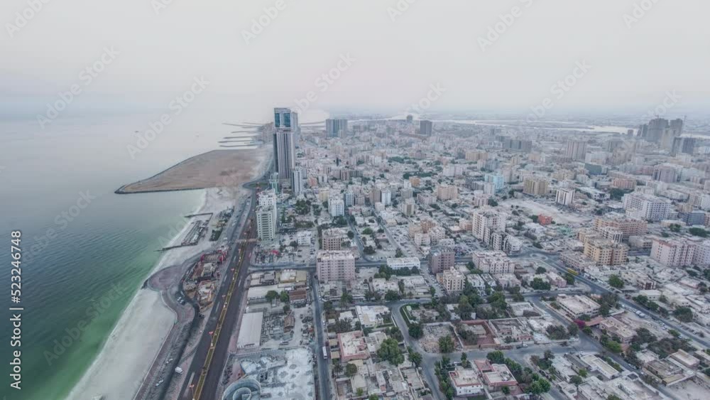 Cityscape of Ajman from rooftop from night to day transition timelapse before sunrise. Ajman is the capital of the emirate of Ajman in the United Arab Emirates. Cityscape of Ajman from rooftop from night to day transition timelapse before sunrise. Ajman is the capital of the emirate of Ajman in the United Arab Emirates.