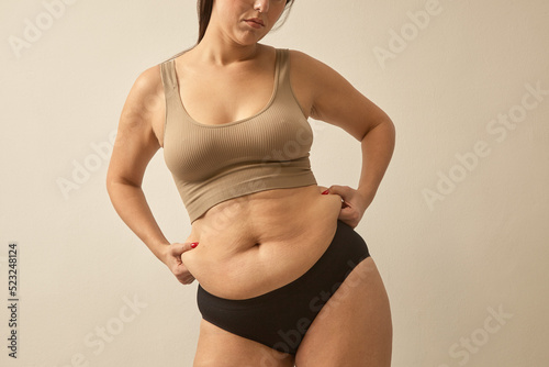 unrecognizable woman pinch abdomen side fat. Body shaming problem, normalize woman body