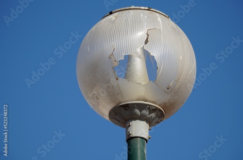 Broken street lamp against the sky