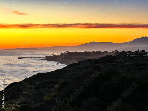 Yellow Sunset along the Pacific Ocean coastline. Casitas Pier of Carpinteria in the background with Santa Barbara.