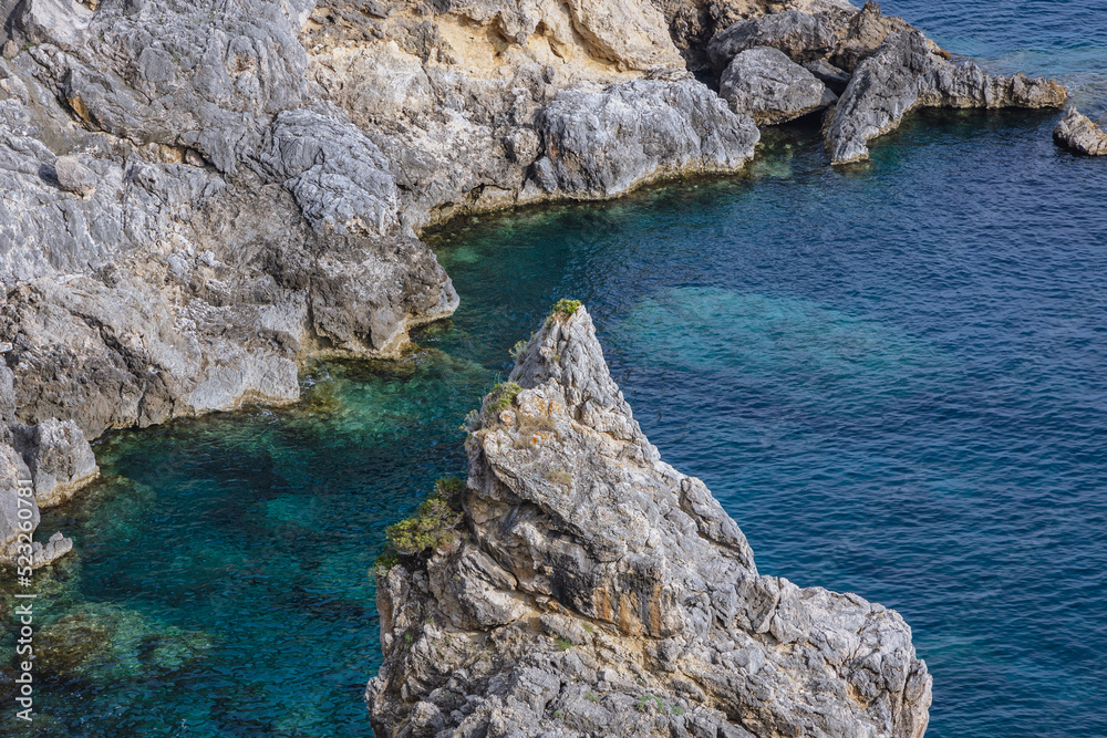 Rocks on Ionian Sea coast in Palaiokastritsa village, Corfu Island in Greece