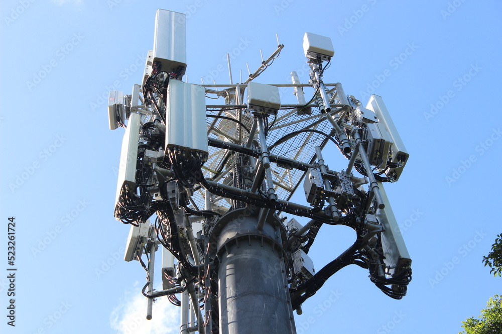 Looking up at a mobile phone tower on a blue sky background