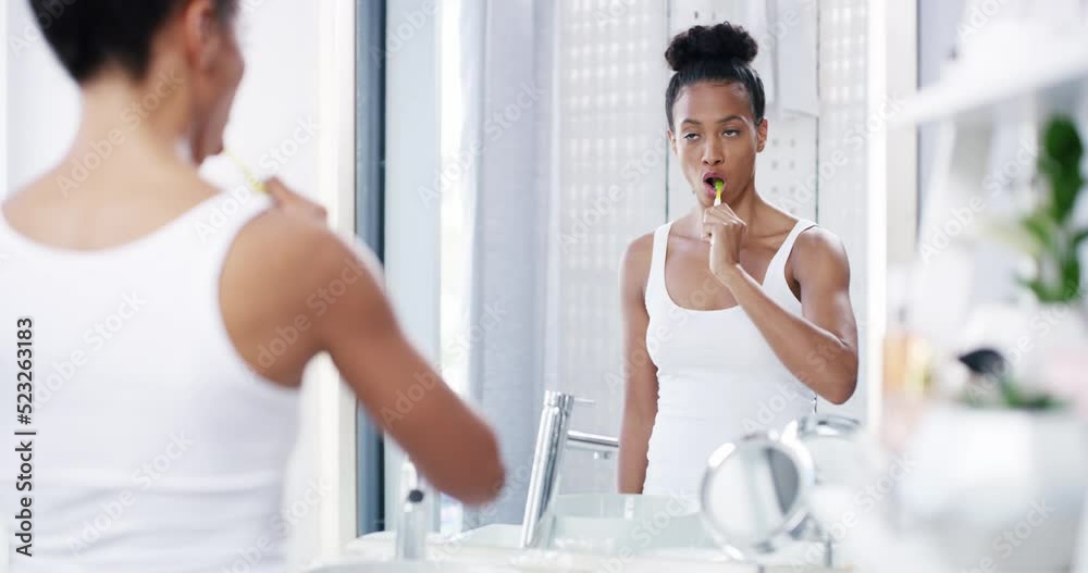 Dental care, brushing teeth and healthy routine in home bathroom in the morning. Sleepy, tired and bored woman checking skin while maintaining hygiene and self grooming with toothpaste and toothbrush Dental care, brushing teeth and healthy routine in home bathroom in the morning. Sleepy, tired and bored woman checking skin while maintaining hygiene and self grooming with toothpaste and toothbrush