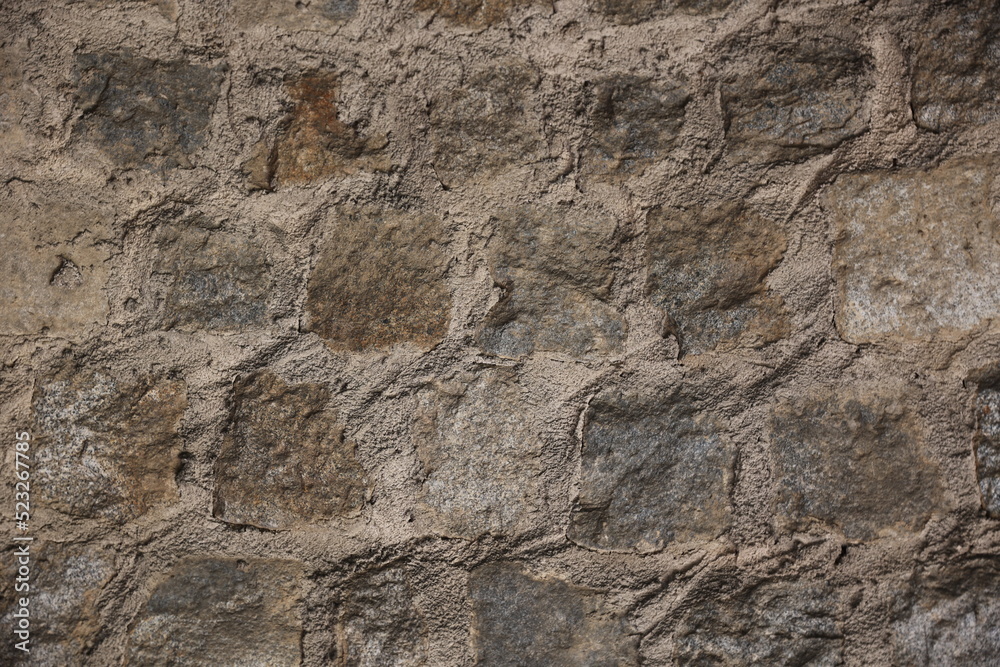 Old stone cobblestone wall covered in dirt and sand medieval old city ancient ruins background concept