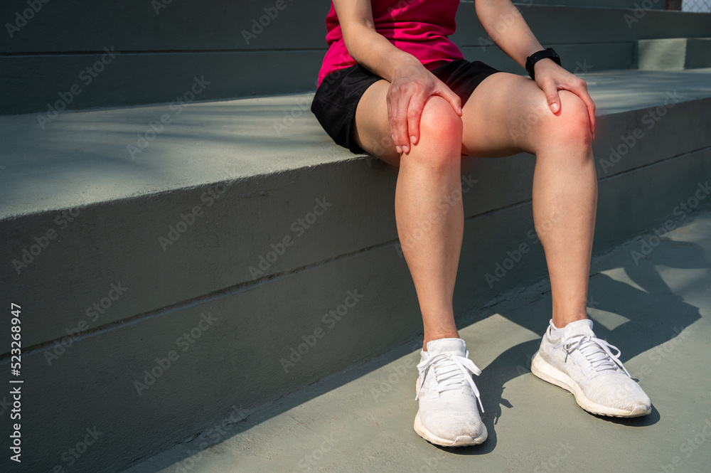 Female runner resting after having knee pain from running. Knee pain