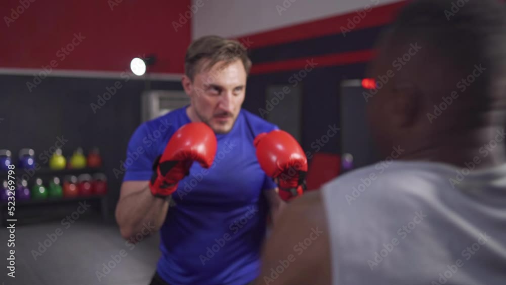 Men with good bodies practice boxing to burn fat. Increase strength and cardio with black American trainers. American black trainer is being targeted for punches for his training partner Men with good bodies practice boxing to burn fat. Increase strength and cardio with black American trainers. American black trainer is being targeted for punches for his training partner