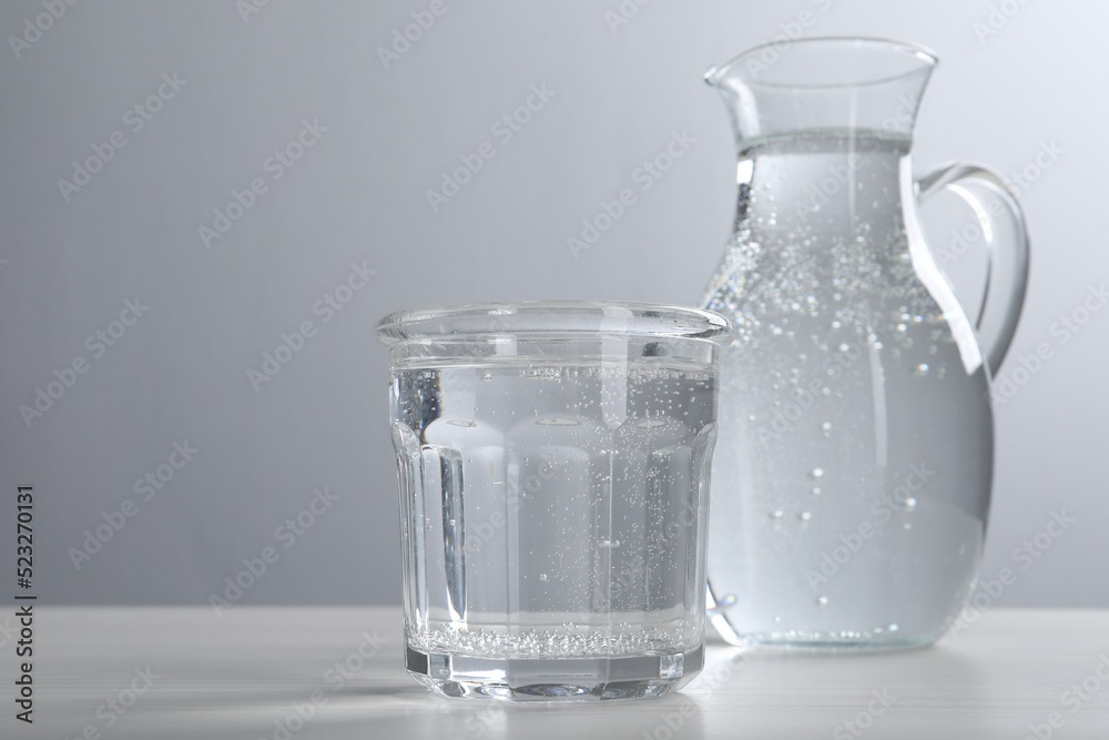 Glassware with soda water on white wooden table. Space for text Glassware with soda water on white wooden table. Space for text